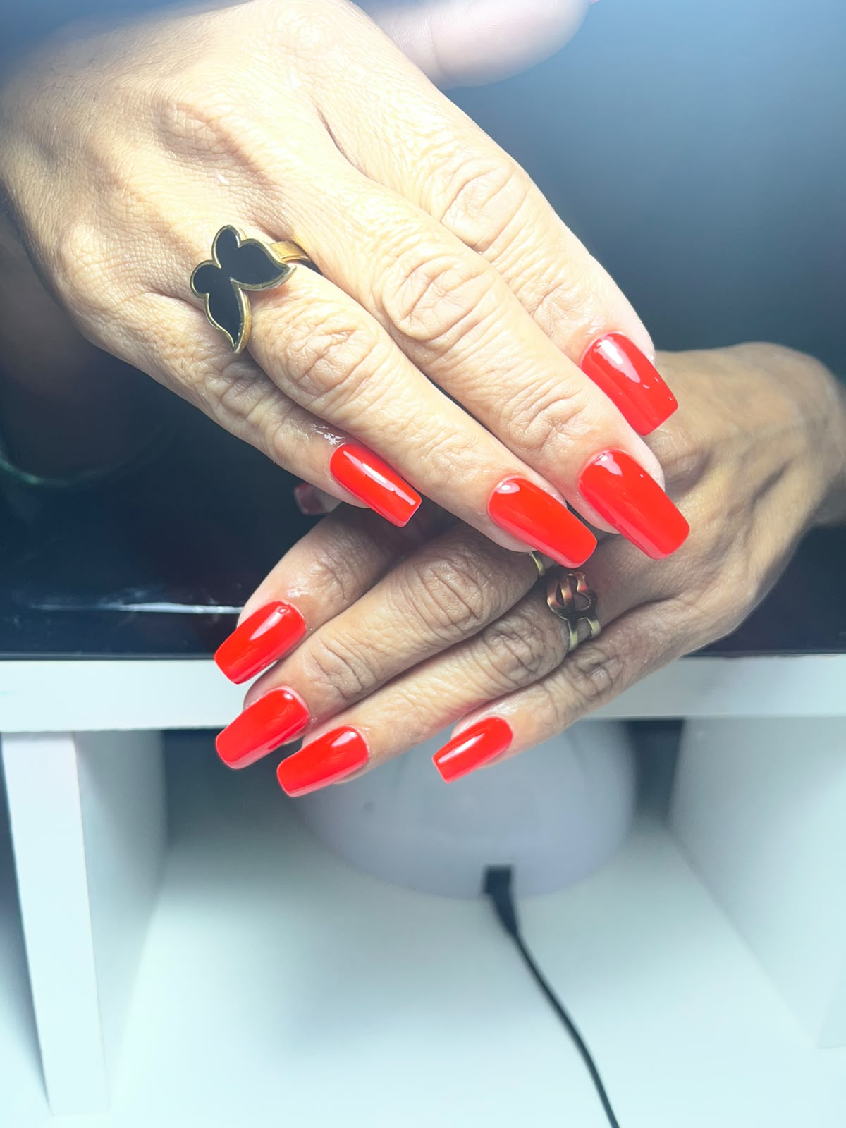 Manicura cuadrada larga en rojo intenso con acabado brillante
